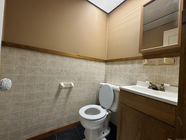 bathroom featuring tile walls, vanity, toilet, and tile patterned floors