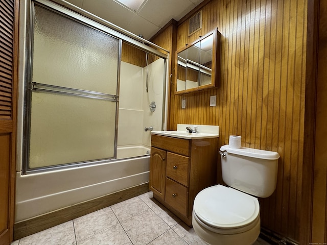 full bathroom featuring toilet, shower / bath combination with glass door, vanity, visible vents, and tile patterned floors