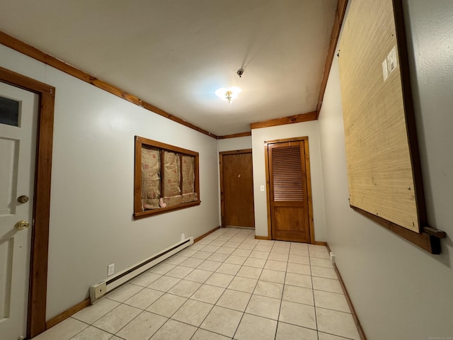 interior space featuring light tile patterned floors, baseboards, a baseboard heating unit, and ornamental molding