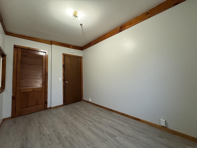 unfurnished bedroom featuring light wood-style flooring and baseboards