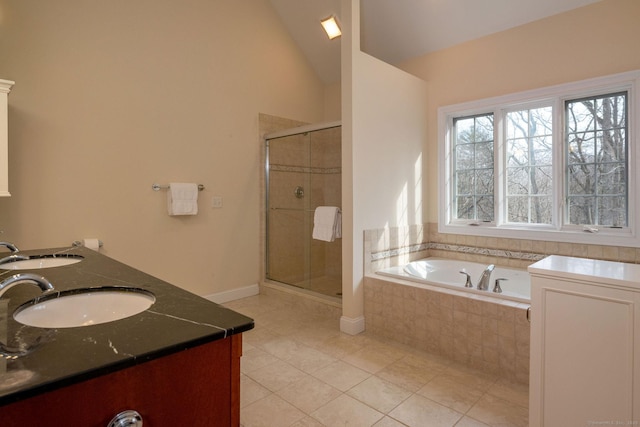 full bath with a stall shower, vaulted ceiling, a garden tub, and a sink