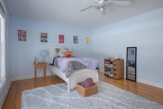 bedroom featuring a ceiling fan, baseboards, and wood finished floors