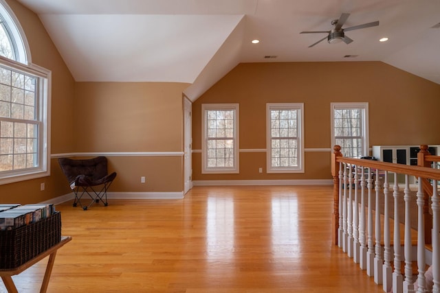 bonus room featuring lofted ceiling, light wood-style floors, and a wealth of natural light