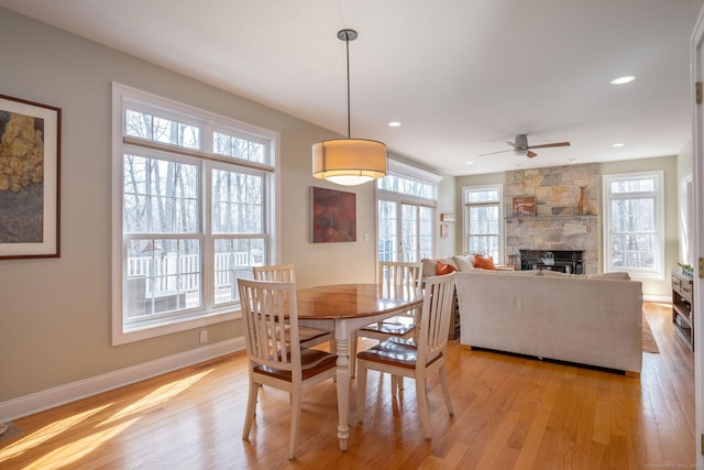 dining room with light wood-type flooring, a wealth of natural light, and baseboards