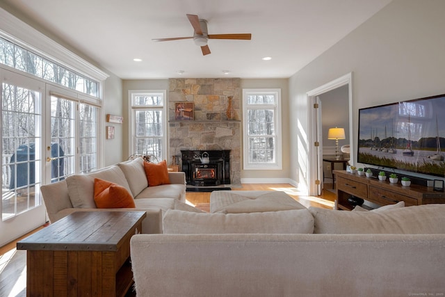 living room featuring a healthy amount of sunlight, baseboards, and wood finished floors