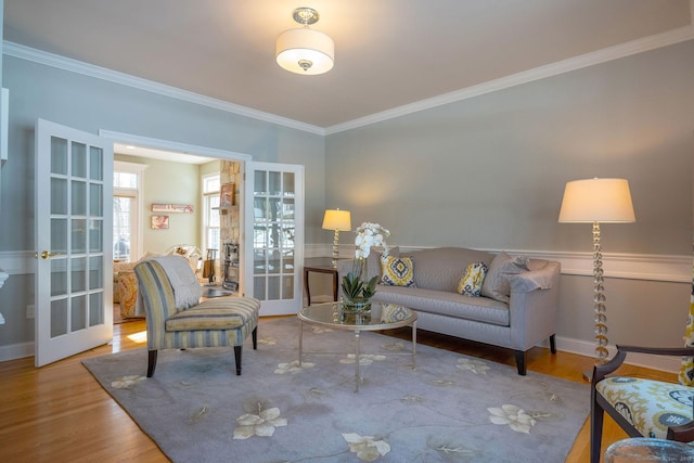 living room with ornamental molding, french doors, and wood finished floors