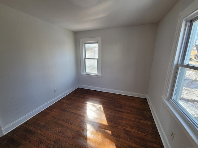 empty room featuring dark wood-style flooring and baseboards