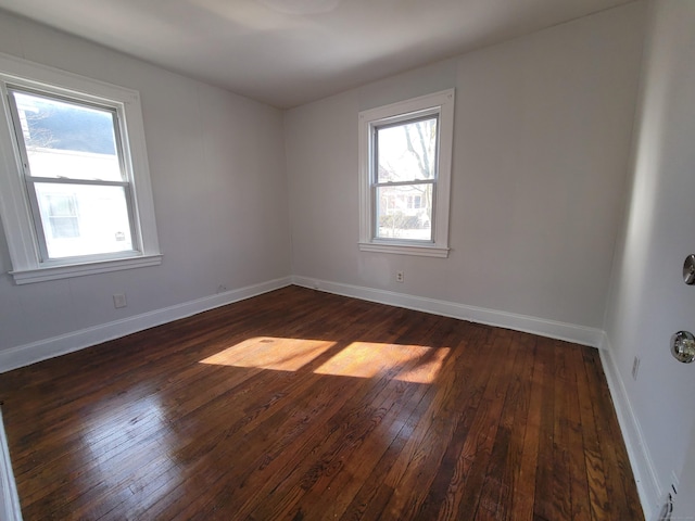 empty room featuring dark wood-style floors and baseboards