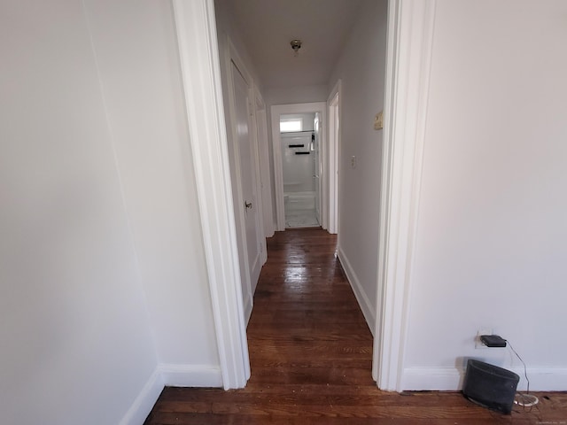 hall featuring dark wood finished floors and baseboards