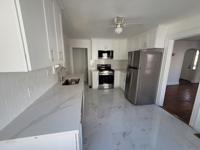 kitchen featuring white cabinets, marble finish floor, stainless steel appliances, and a sink