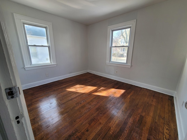 empty room with dark wood-type flooring and baseboards