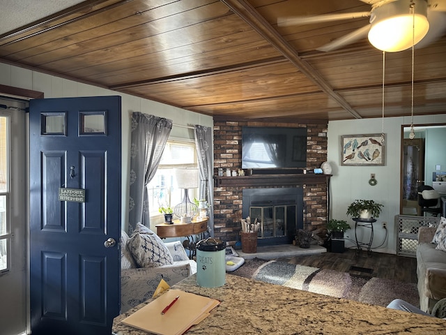 living room with a brick fireplace, wood ceiling, and wood finished floors