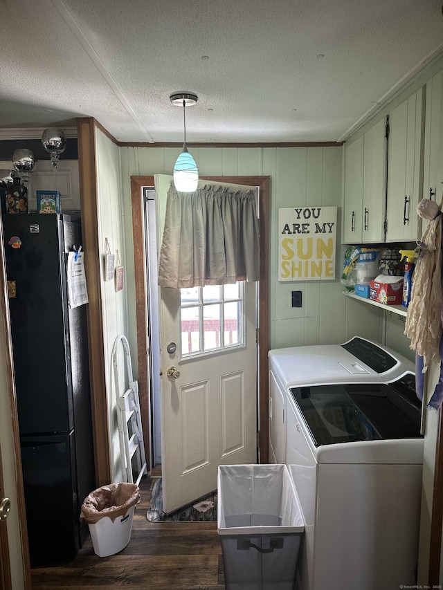 clothes washing area featuring cabinet space, dark wood-type flooring, ornamental molding, a textured ceiling, and independent washer and dryer