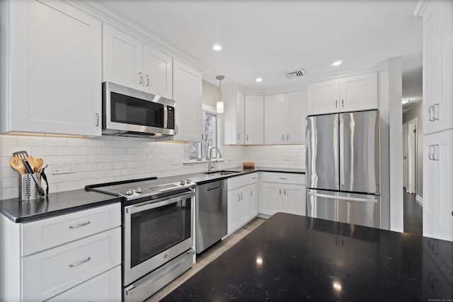 kitchen with visible vents, hanging light fixtures, appliances with stainless steel finishes, white cabinetry, and a sink