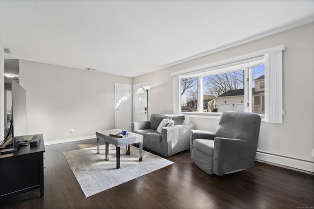 living room with a baseboard heating unit, visible vents, dark wood finished floors, and baseboards