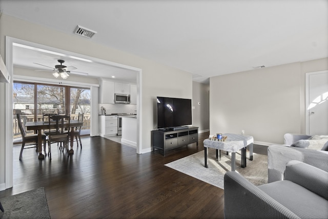 living area featuring baseboards, visible vents, and dark wood-type flooring