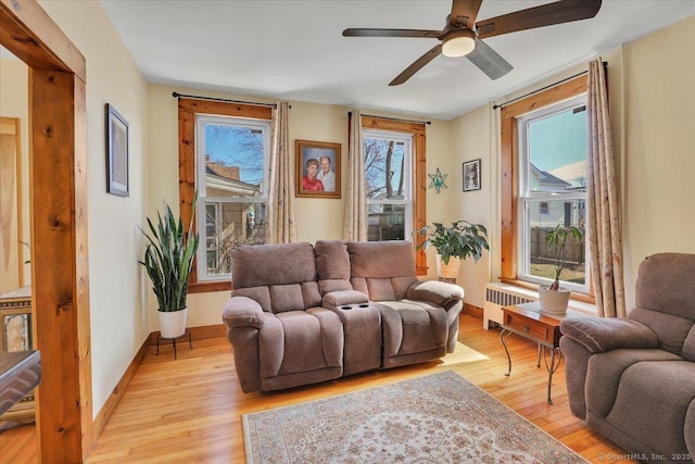 living room featuring baseboards, a healthy amount of sunlight, and light wood-style flooring