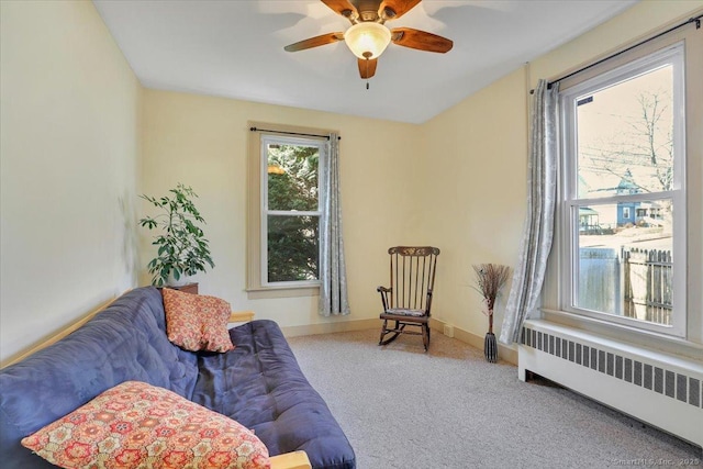 living area with radiator, carpet, baseboards, and ceiling fan