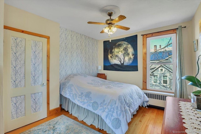 bedroom featuring ceiling fan, wood finished floors, and radiator heating unit