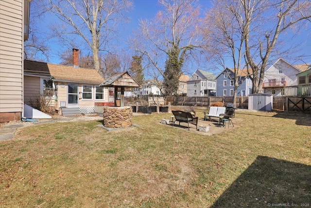 view of yard featuring entry steps, a fenced backyard, a shed, a residential view, and an outdoor structure