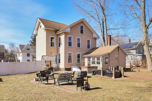 back of property featuring a patio area, a lawn, and fence