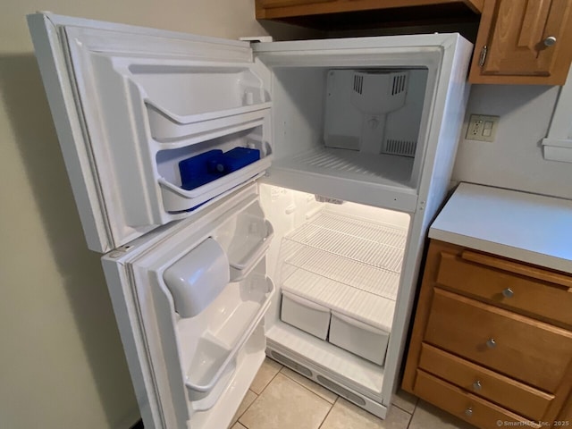 room details with light countertops, fridge, and brown cabinets