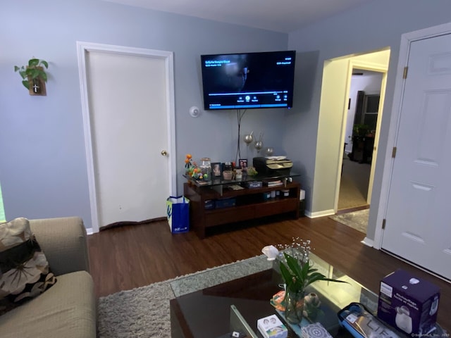 living area featuring baseboards and wood finished floors