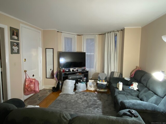 living room with ornamental molding and wood finished floors
