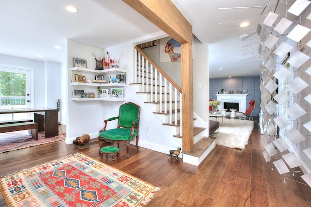 interior space featuring a brick fireplace, baseboards, wood finished floors, and recessed lighting