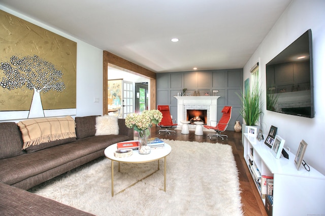 living area with a brick fireplace, dark wood-type flooring, and recessed lighting