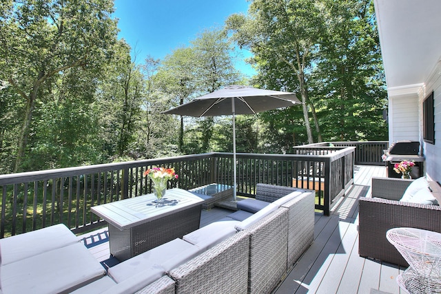 wooden terrace with a grill and outdoor lounge area