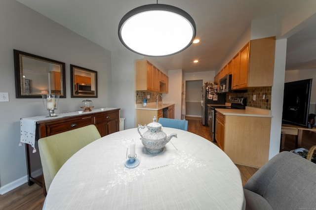 dining space featuring dark wood-style floors, baseboards, and recessed lighting