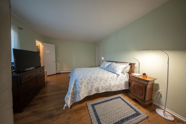 bedroom with a baseboard radiator and wood finished floors