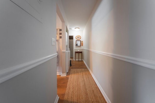 corridor with wood finished floors and baseboards