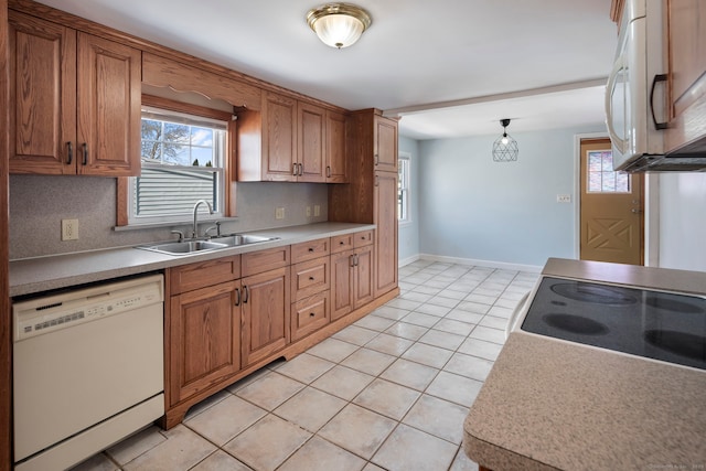 kitchen featuring light countertops, white appliances, and a sink