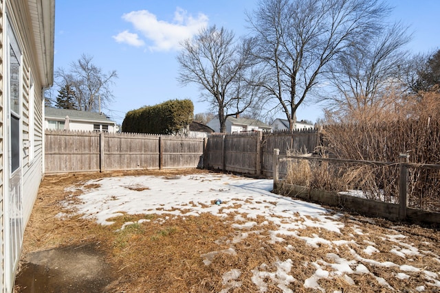 yard covered in snow with a fenced backyard