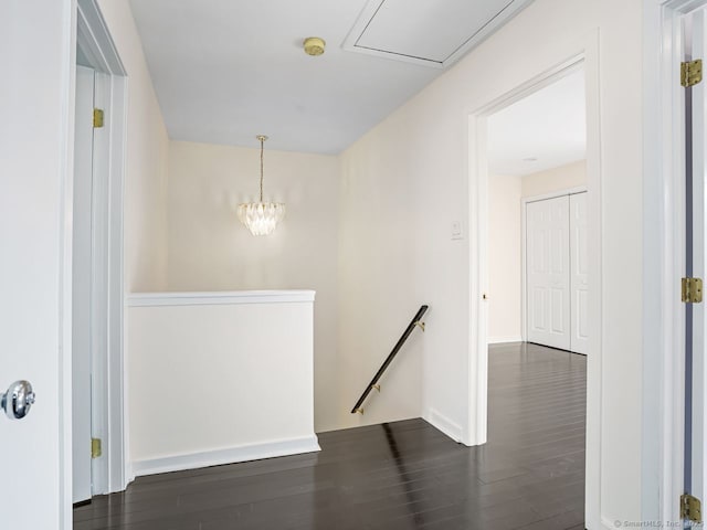 corridor with dark wood-style flooring and an upstairs landing