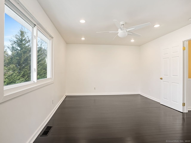 unfurnished room featuring baseboards, dark wood-type flooring, visible vents, and recessed lighting