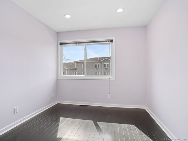 unfurnished room featuring visible vents, baseboards, wood finished floors, and recessed lighting