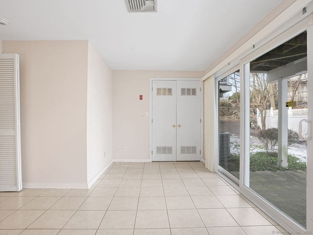 interior space with light tile patterned floors, visible vents, and baseboards