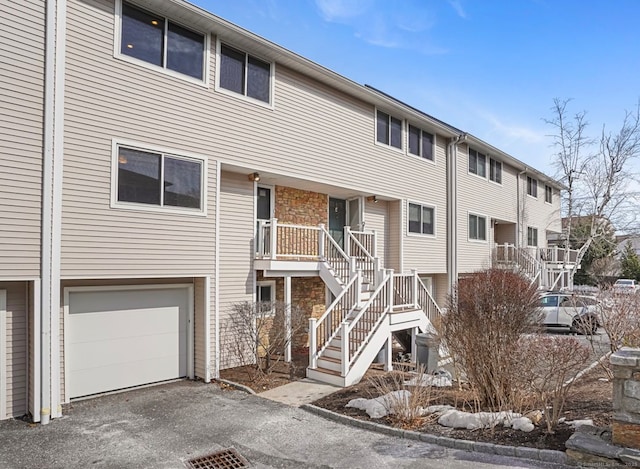 exterior space featuring stairs, driveway, and an attached garage