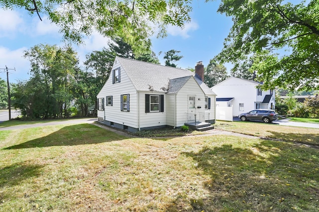 view of front of home featuring a shingled roof, a chimney, and a front lawn