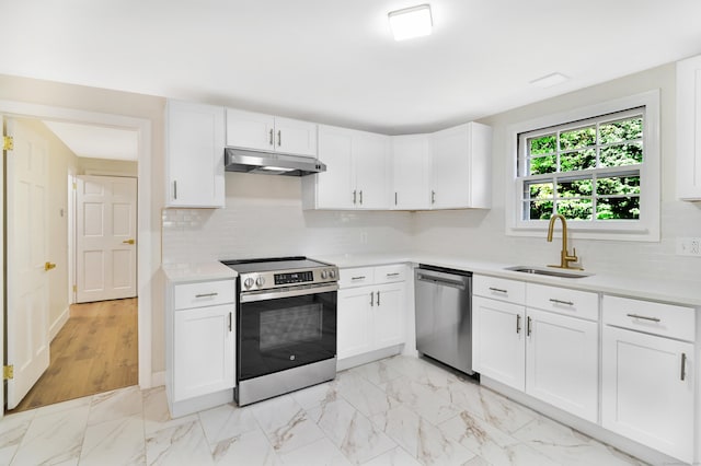 kitchen with stainless steel appliances, white cabinets, light countertops, and under cabinet range hood