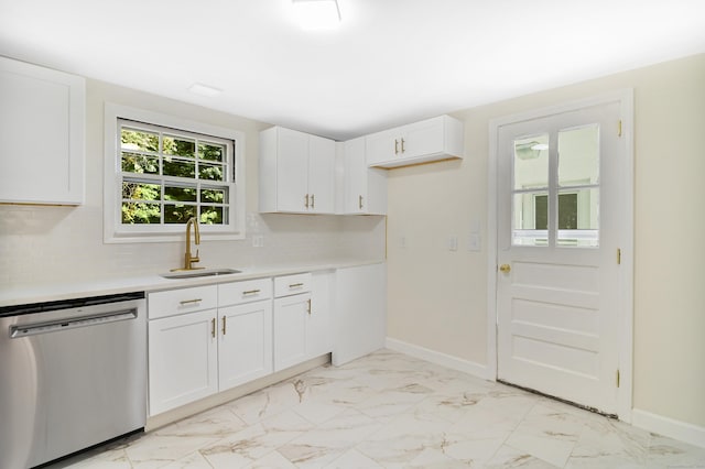 kitchen with white cabinets, marble finish floor, light countertops, and stainless steel dishwasher