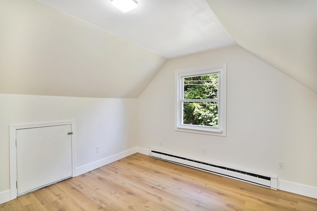 bonus room with lofted ceiling, baseboard heating, baseboards, and light wood-style floors