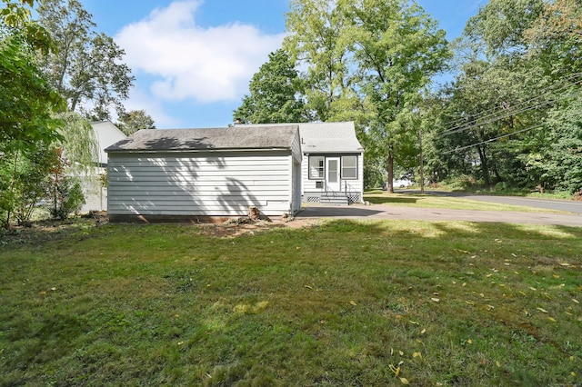 back of property featuring a yard