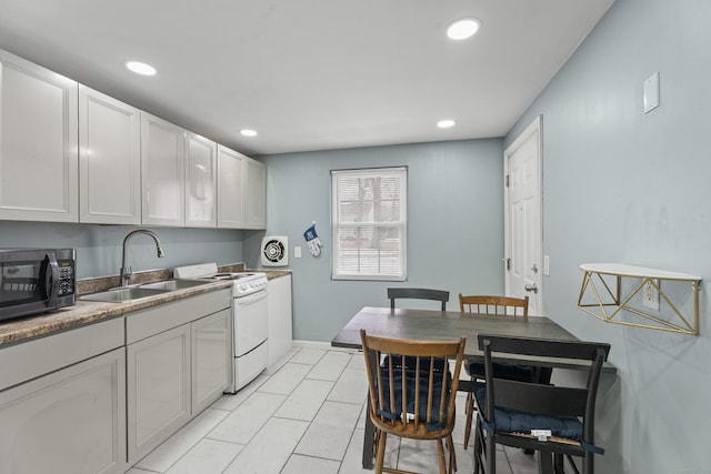 kitchen featuring recessed lighting, white electric range, stainless steel microwave, white cabinetry, and a sink