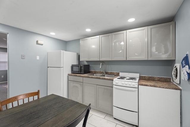 kitchen with white appliances, dark countertops, a sink, and recessed lighting