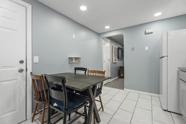 dining space featuring recessed lighting, light tile patterned flooring, and baseboards