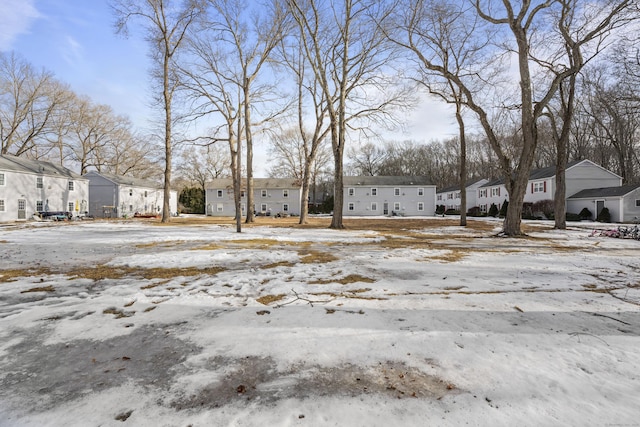 snowy yard featuring a residential view